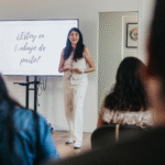 Bea Doula dando charla sobre señales de trabajo de parto frente a un grupo, con pantalla que dice "¿Estoy en trabajo de parto?"